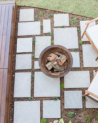 Concrete pavers and fire pit next to lawn