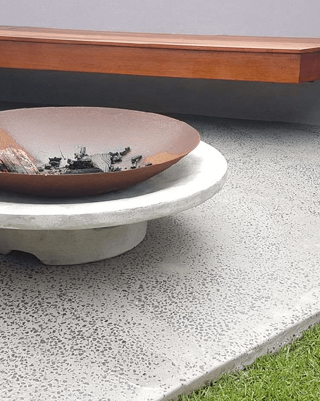 Built in seating on polished concrete featuring fire pit and Empire Zoysia turf