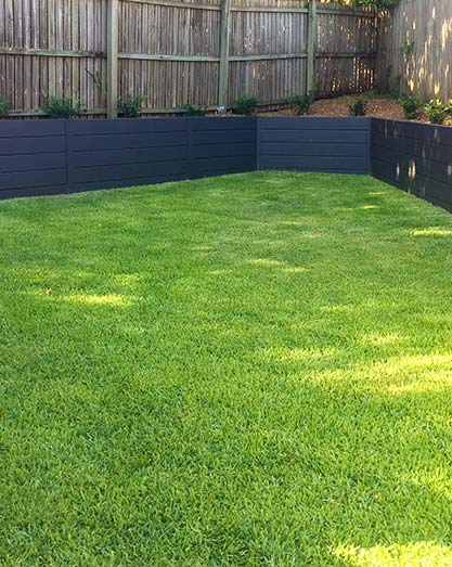 Natural Empire Zoysia turf with cement sleeper retaining wall