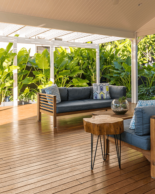 Timber deck construction with lush heliconias creating a privacy screen for outdoor lounge space
